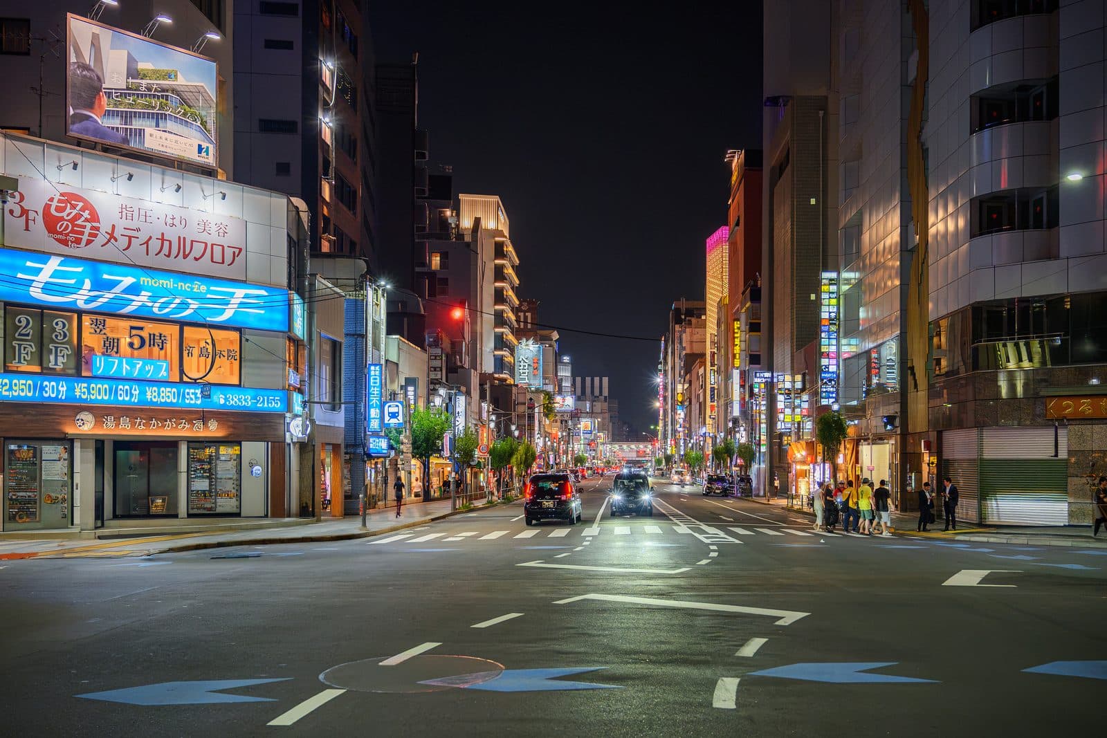夜の湯島駅周辺の交差点と店舗看板